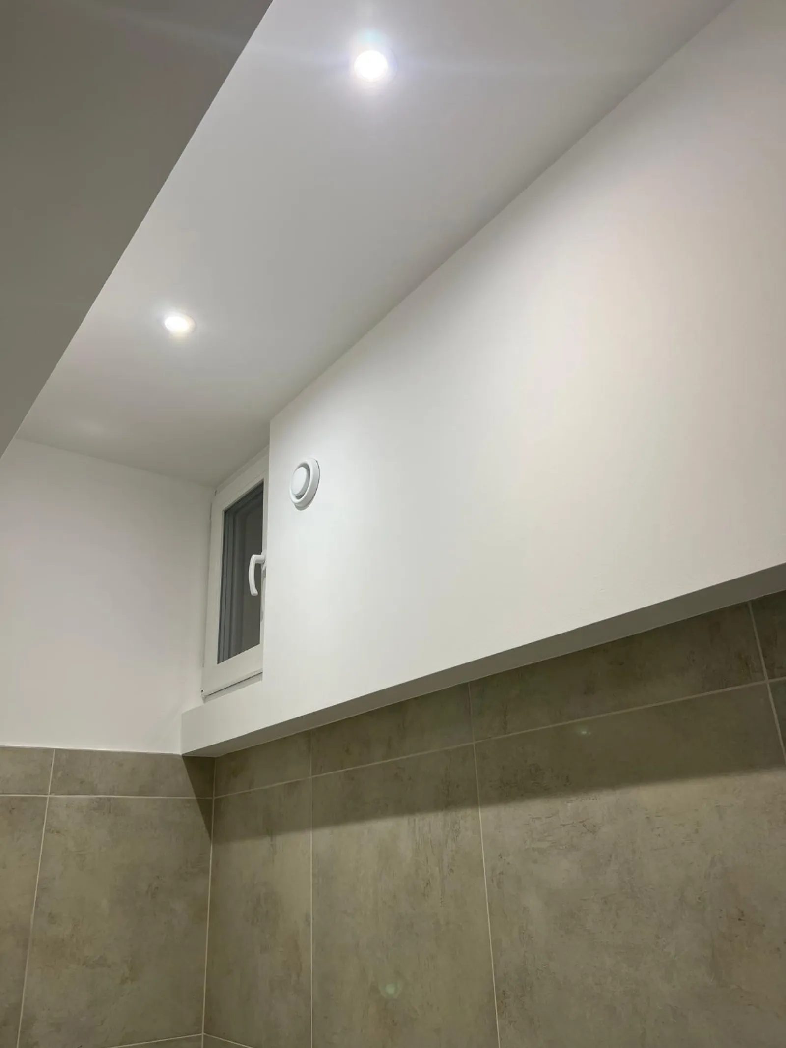 Pièce finie avec carrelage beige et spots LED encastrés