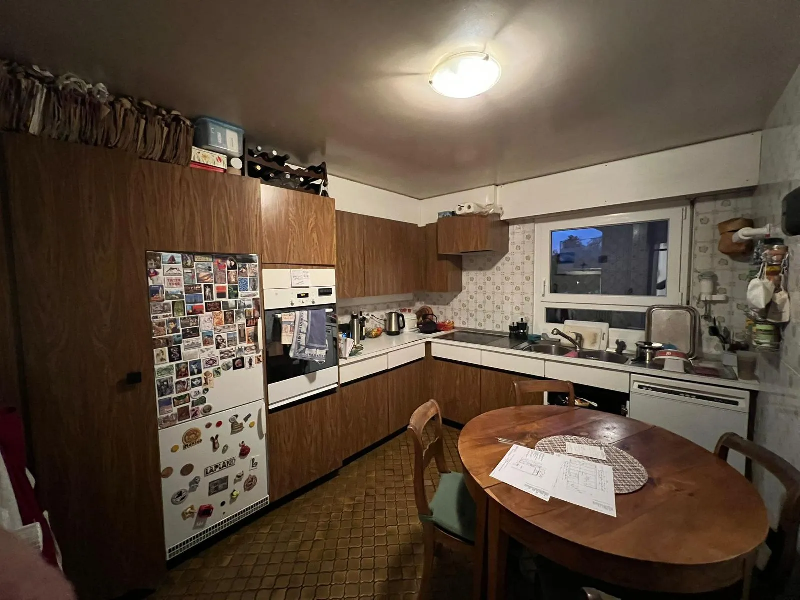 Cuisine ancienne en bois marron avec frigo aimanté — avant rénovation