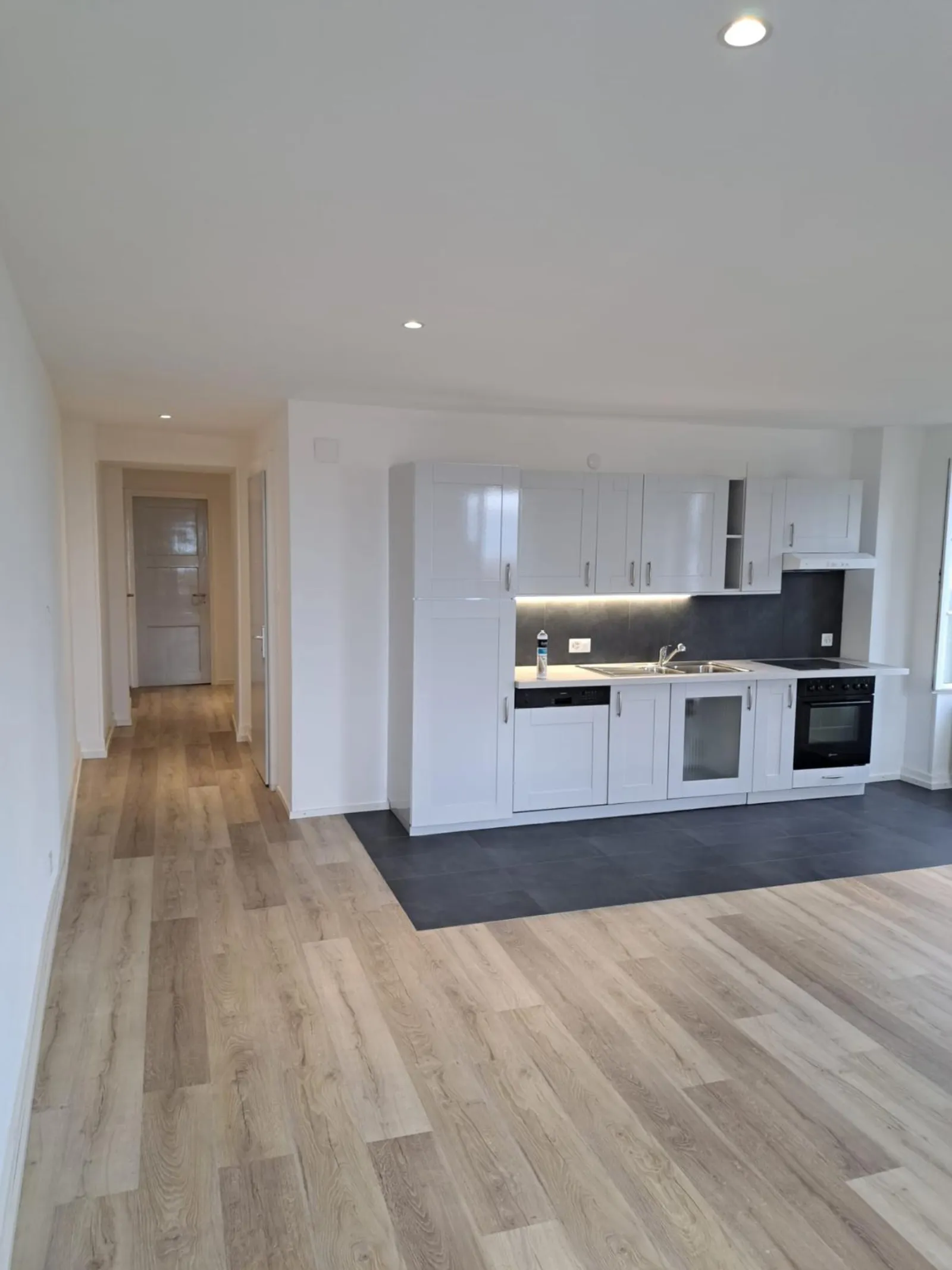 Cuisine blanche moderne avec dosseret anthracite après rénovation Riviera
