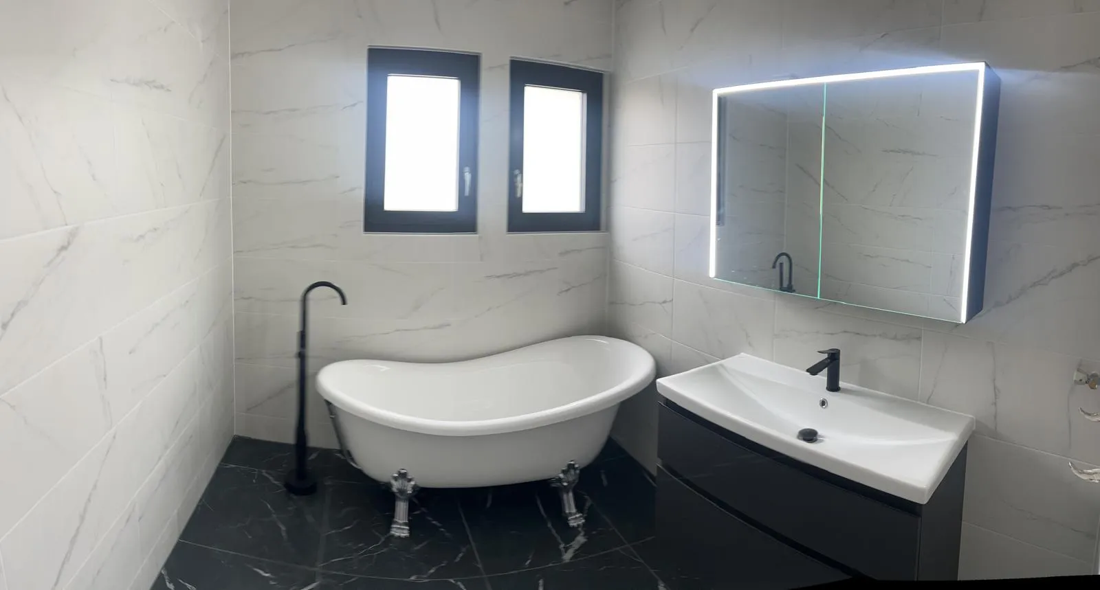 Salle de bain marbre blanc, baignoire îlot avec pieds chromés