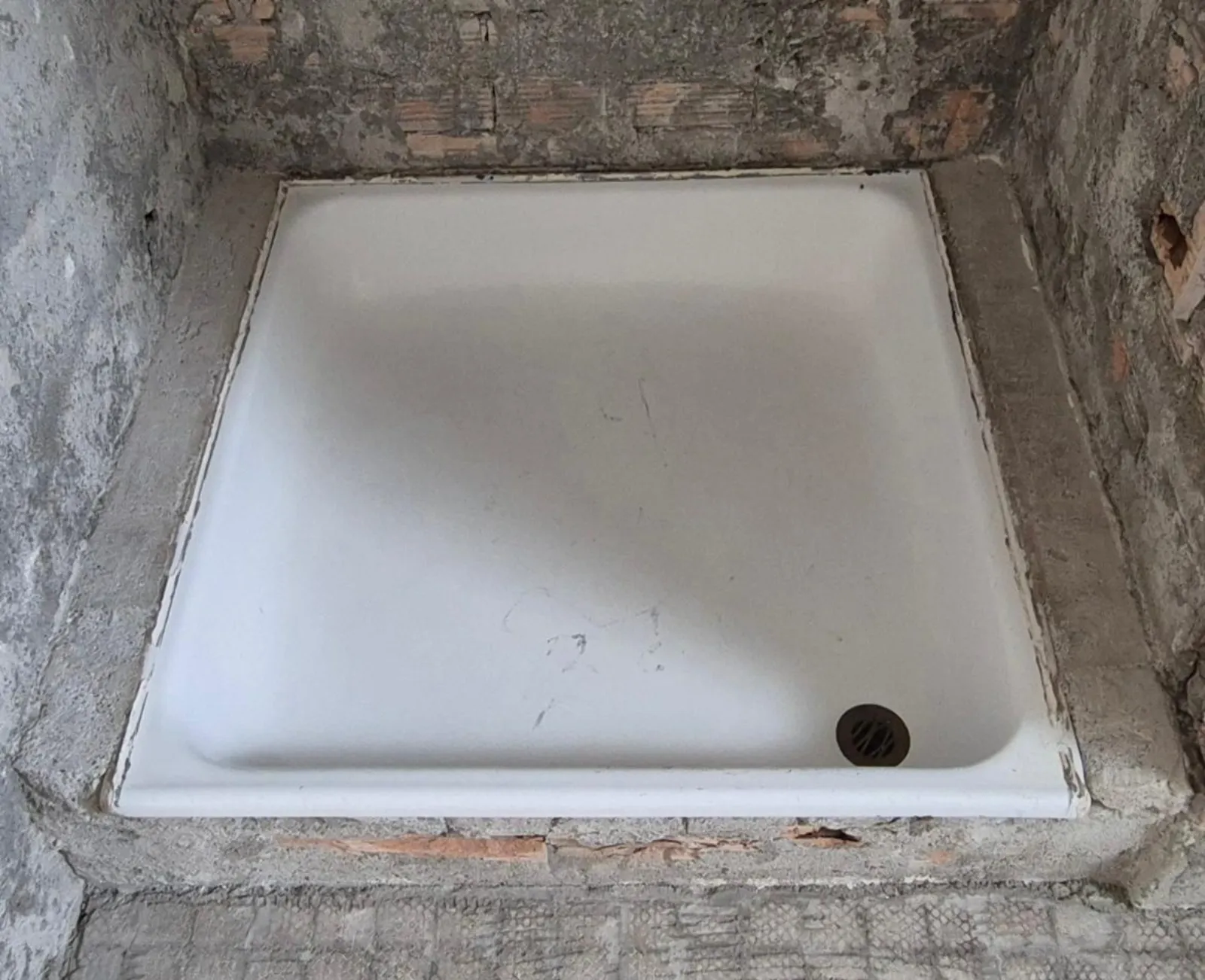 Receveur de douche pendant le chantier, mur en briques apparentes